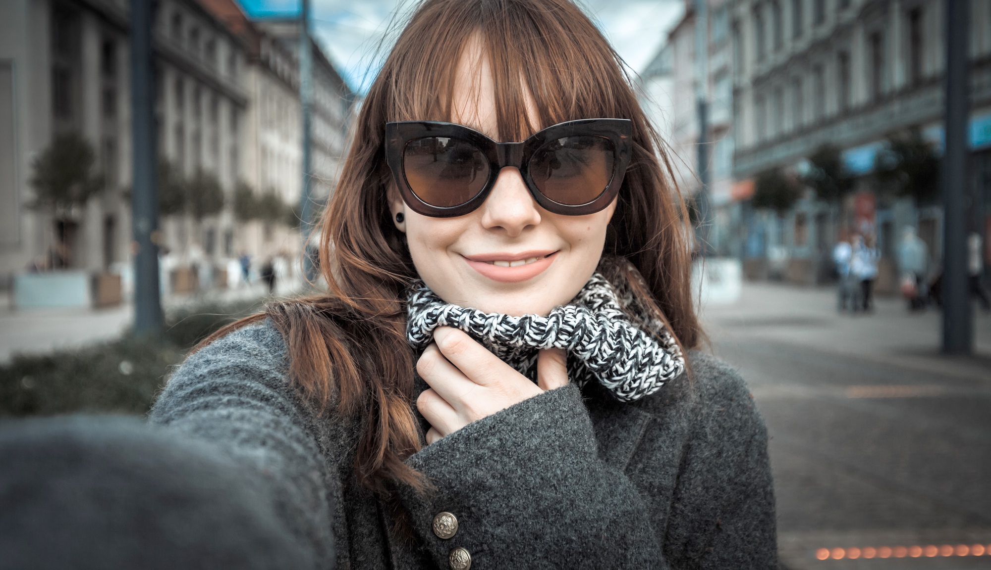 Smiling pretty woman selfie portrait at the city